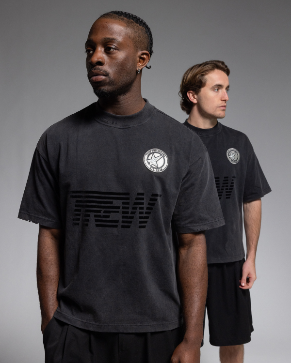 Two models wearing Trew Collections Black on Black Tee, posed against a neutral gray studio background.
